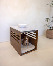 Dog crate with a cushion inside, placed on a white surface with a neutral background.