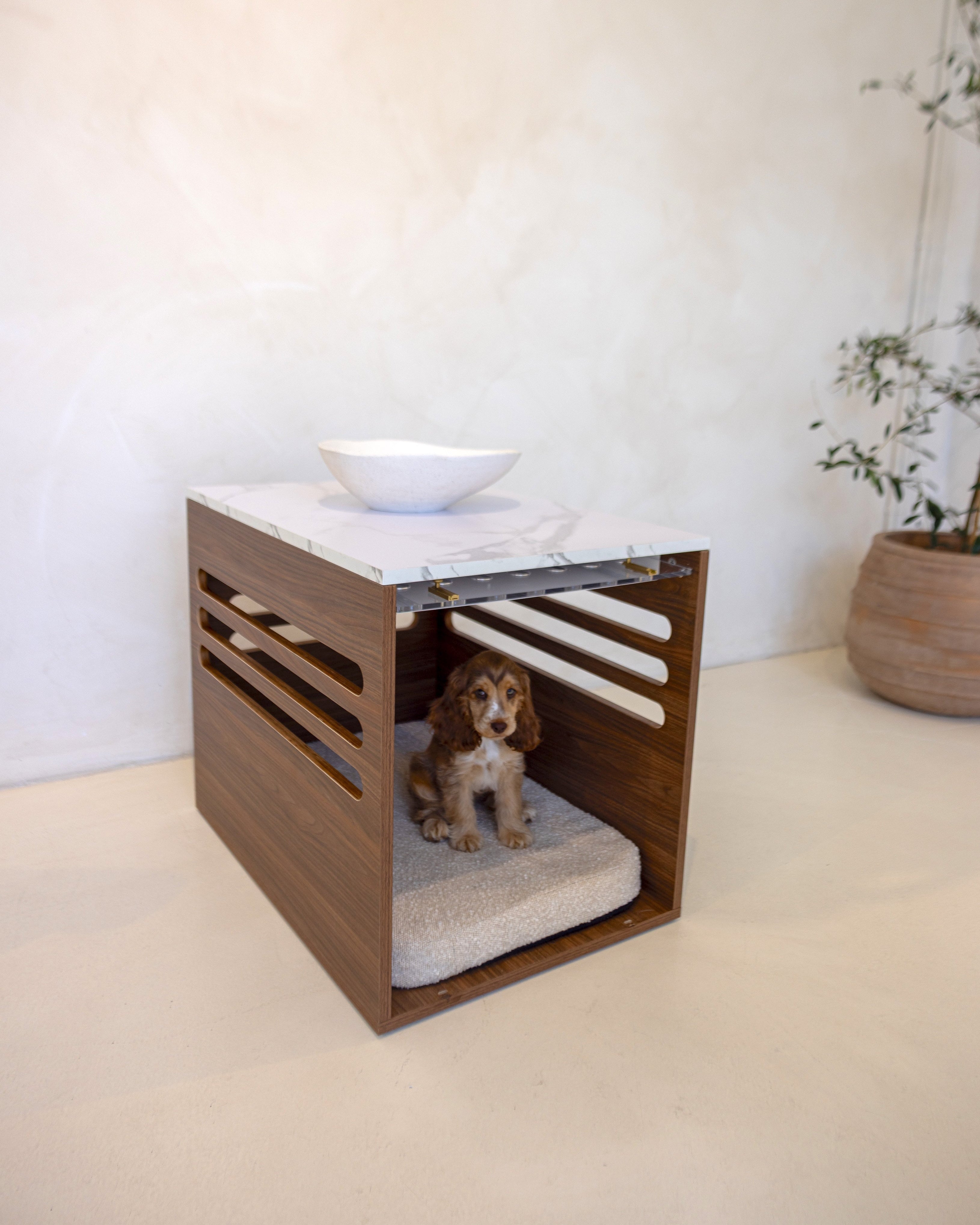 Dog crate with a cushion inside, placed on a white surface with a neutral background.