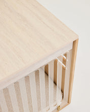 Wooden crib with a white mattress on a light background