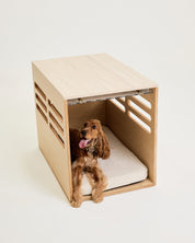 Dog inside a modern wooden pet bed on a light background
